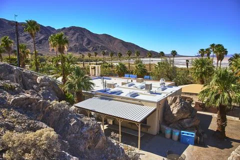 Student Group Desert Study Center Building with Palm Trees Rocky Hills in M.. Stock Photos