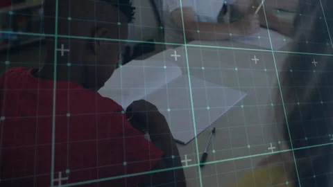 Student group writing on paper at classroom desk, showing education tech with Stock Footage 307443403