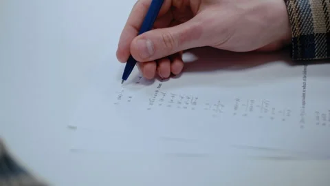 Student hand solving math problems on exam paper Stock Footage 335127548