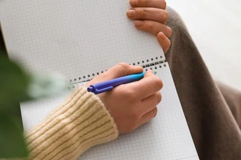 Student hand writing notes in grid notebook with pen, education and learning  Stock Photos