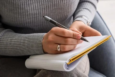 Student hand writing notes in notebook with pen, education and learning conce Stock Photos