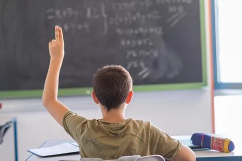 Student with hands up in classroom during a lesson Stock Photos
