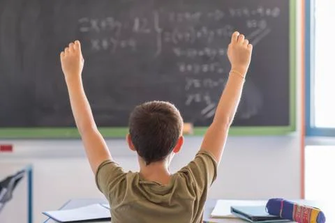 Student with hands up in classroom during a lesson Stock Photos
