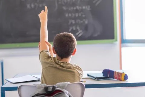 Student with hands up in classroom during a lesson Stock Photos