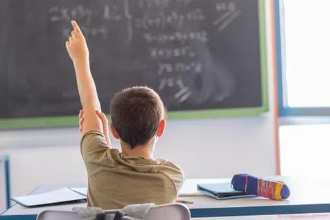 Student with hands up in classroom during a lesson 스톡 사진