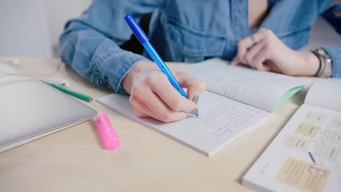 Student hands writing to notebook at table doing homework exercises and studying Video stock 103285340