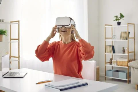 Student is happy to use innovative virtual reality glasses during her online Stock Photos