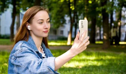 Student having a funny video call and laughing in the park during break in un Stock Photos