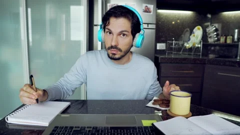 Student with headphone taking notes and online classes Stock Footage 136091576