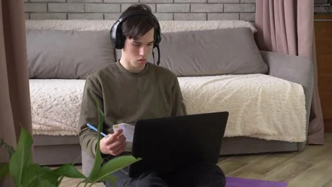 Student with headphones and a microphone study online at home Stock Footage 159409909
