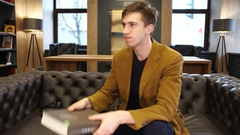 Student hits himself on the head with a huge book Stock Footage 155962822