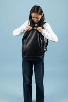 Student Holding a Black Backpack on Blue Background Stock Photos