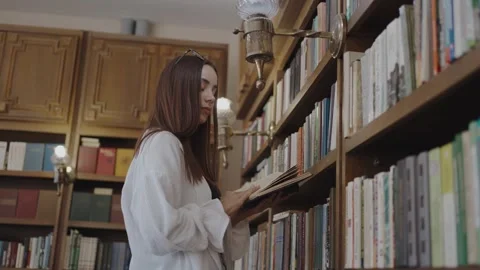 A student holding a book in the library Stock Footage 252062026