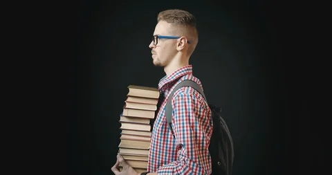 Student Holding Stack of Books Isolated on Black Stock Footage 122938133