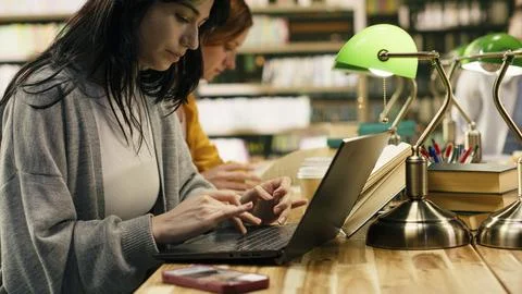 Student ignoring laptop work and notes after phone notification Foto stock
