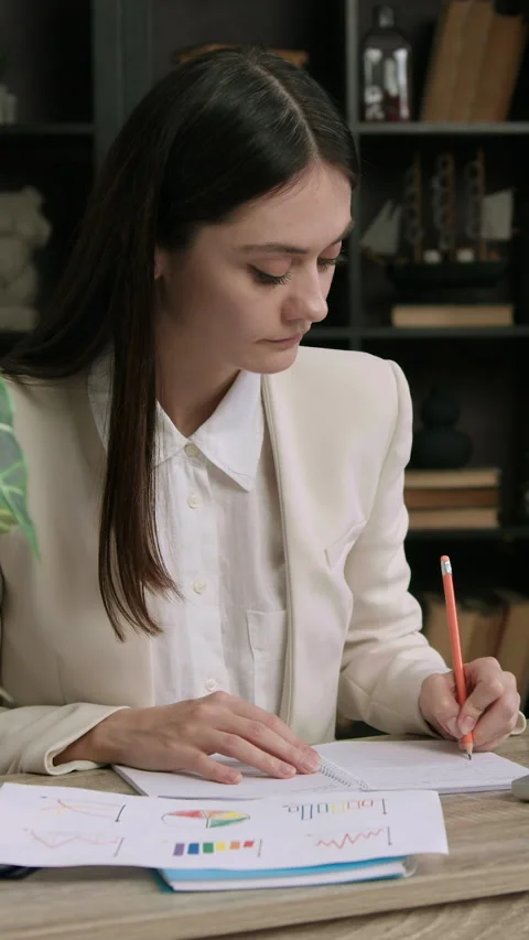 Student intern in classic suit sitting at an office table. Woman analyzing Stock Footage 305412508