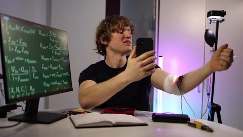 Student joins an online session while showing a glowing AI chip on his arm Stock Footage 323270945