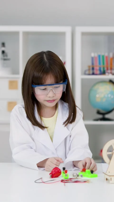 Student in Lab Coat Conducting Electronics Experiment in Science Classroom Stock Footage 341392729