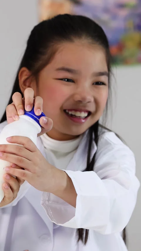 Student in Lab Coat Conducting Science Experiment with Plastic Bottle Stock Footage 337862559