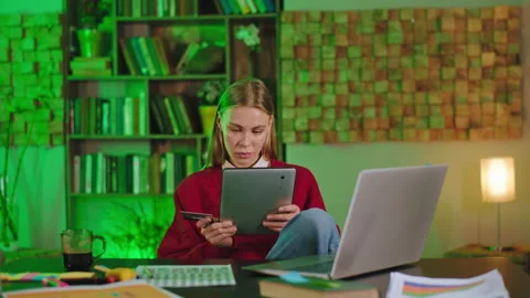 Student lady using a credit card to buy something from the electronic tablet Stock Footage 144205246