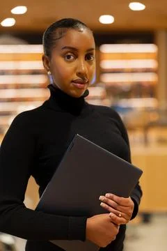 Student with laptop in library setting Stock Photos
