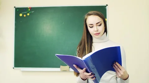 Student leafing through notebook in classroom Video stock 111997676