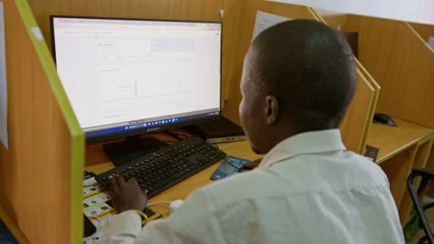 Student learning internet skills at computer workstation in African internet Stock Footage 346880642
