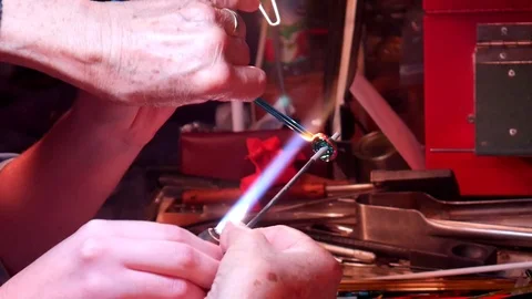 A Student Learning to Melt Glass and Add to Mandrel with a Fire Cut Vidéo 99574524