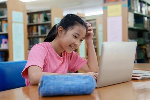 Student learning online class by using laptop computer and writing notebook a Fotos de archivo