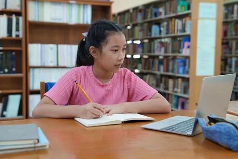 Student learning online class by using laptop computer and writing notebook a Stock-Fotos
