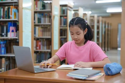 Student learning online class by using laptop computer and writing notebook a Stock Photos