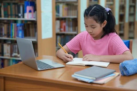 Student learning online class by using laptop computer and writing notebook a 写真素材