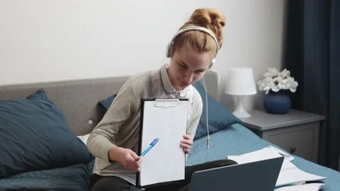 Student learning online, watching lesson remotely, talking with classmates on Stock Footage 146338965