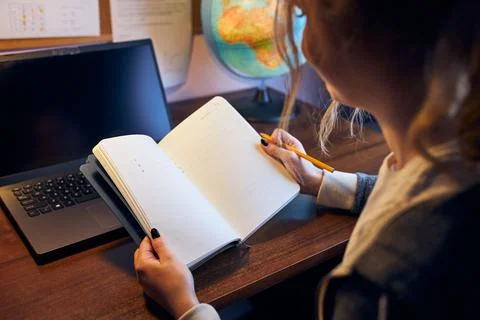 Student learning remotely from home. Young woman having classes online, mak.. Stock Photos
