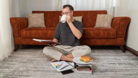 The student learns lessons and prepares for the exam, drinks coffee while Stock Photos