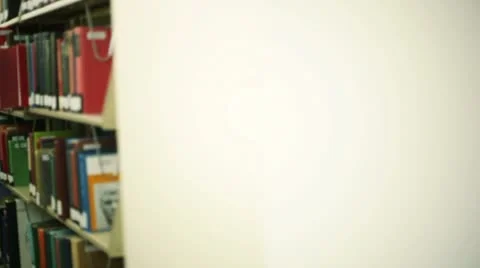 Student in library, pulling book off shelf Stock Footage 8838917