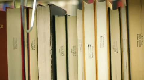 Student in library, pulling book off shelf Video stock 8860604