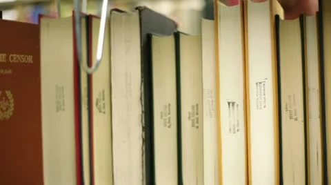 Student in library, pulling book off shelf Video stock 8860865