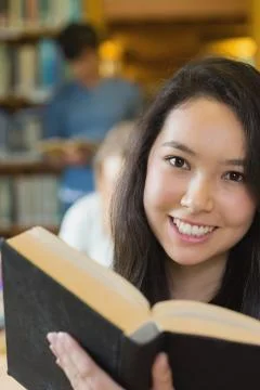 Student in library reading book Stock Photos