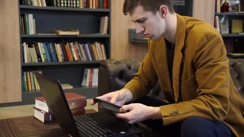Student in library working on laptop 스톡 동영상 155963296