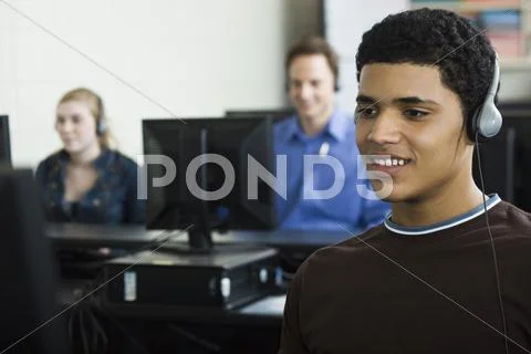 Student Listening To Headphones In Computer Lab