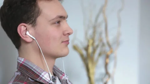 A student listens to music while sitting at home with headphones, a young man Stock Footage 131929434
