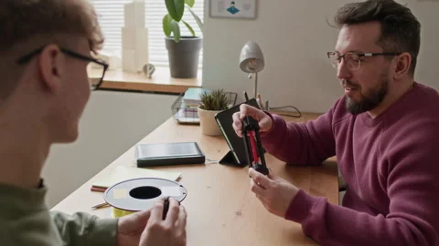 Student Listenting to Teacher Explaining 3D Printed Model to him in Classroom Stock Footage 335695547