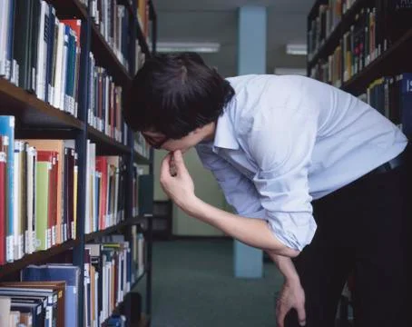 Student looking at books in a library Stock Photos