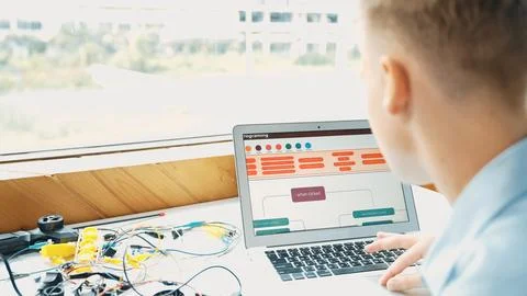 Student looking at laptop screen while coding engineering prompt. Edification. Stock Photos