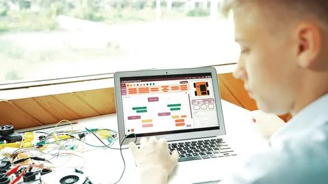 Student looking at laptop screen while coding engineering prompt. Edification. Stock Photos