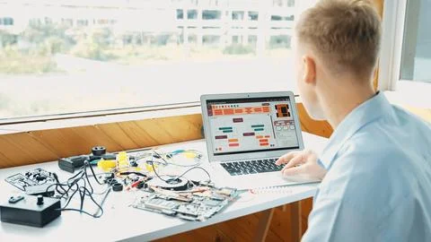 Student looking at laptop screen while coding engineering prompt. Edification. Foto stock