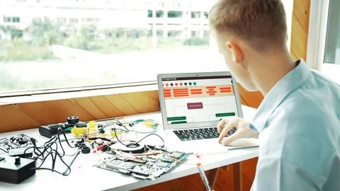 Student looking at laptop screen while coding engineering prompt. Edification. 스톡 사진