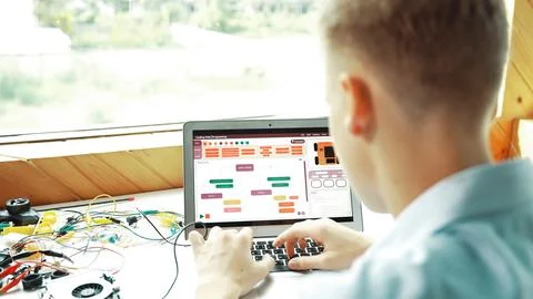 Student looking at laptop screen while coding engineering prompt. Edification. Stock Photos