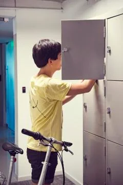 Student looking for something in locker Stock Photos